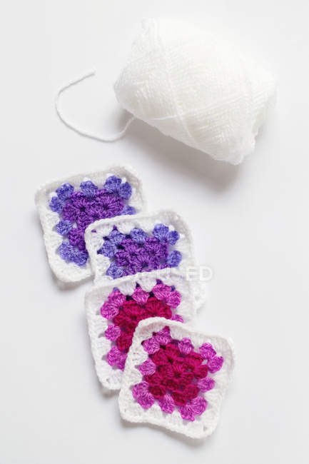 Crocheted doilies and white skein of yarn, white background — Stock Photo