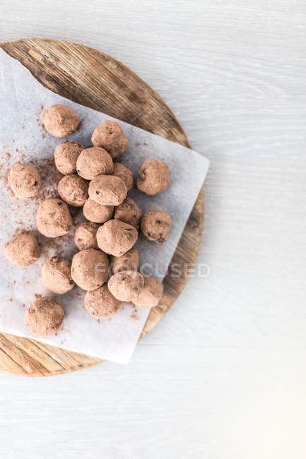 Elevated view of chocolate truffles on a chopping board — Stock Photo