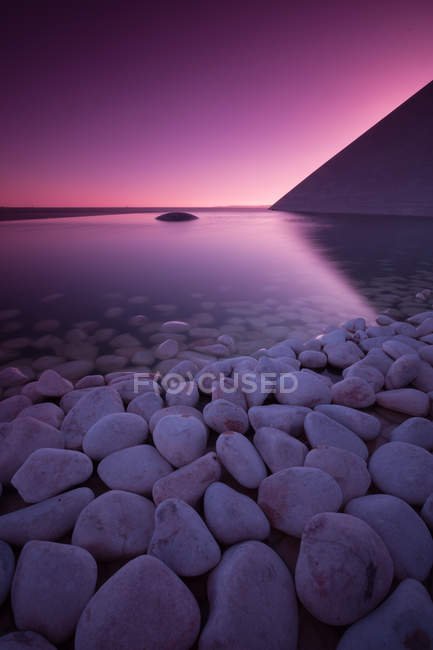 Scenic view of pebbles and still reservoir, Lisbon, Portugal — Stock Photo