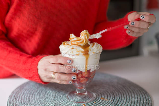 Cropped image of woman eating an ice cream with strawberries — Stock Photo