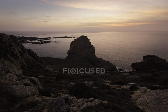 Linea costiera pinnacolo roccia sagomato contro il mare al tramonto, Jersey, Stati Uniti d'America — Foto stock