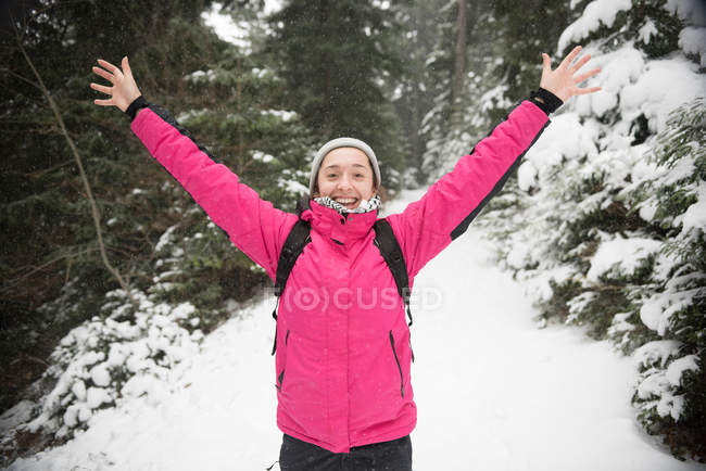 Femme debout dans la neige avec les bras dans l'air — Photo de stock