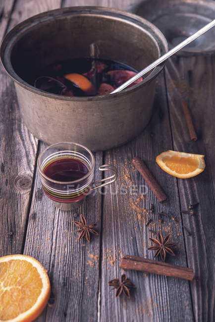Vinho amassado, laranjas, anis estrelado e canela em uma mesa de madeira rústica — Fotografia de Stock