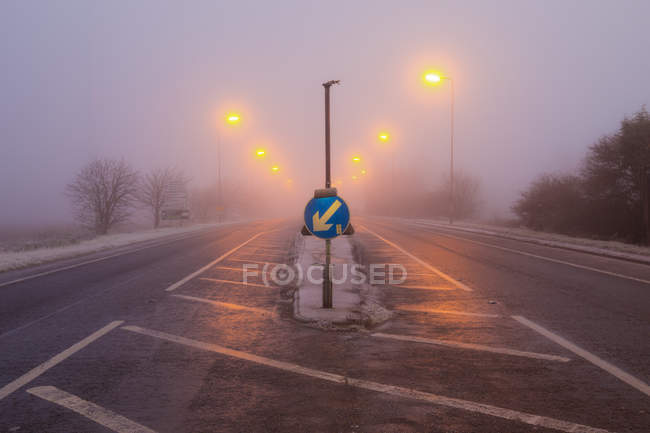 Gefrierender Nebel Straße in der Früh und Abbiegeschild, cambridgeshire, england, uk — Stockfoto