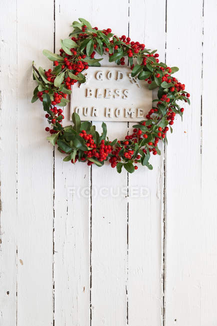 Dio benedica la nostra casa segno sulla porta circondata da ghirlanda — Foto stock