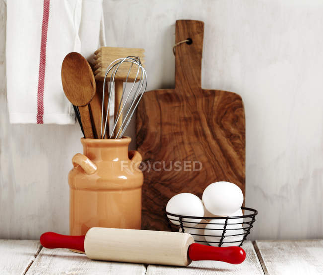 Композиція кухонного посуду та яєць в кошику — стокове фото