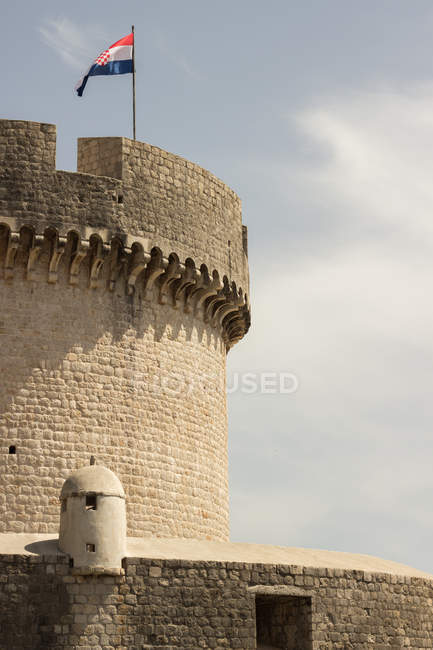 Torre del castillo con bandera croata ondeante, Dubrovnik, Croacia - foto de stock