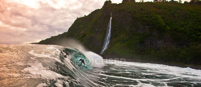 Соединенные Штаты Америки, Гавайские острова, Огромная волна с человеком внутри бочки на закате — стоковое фото