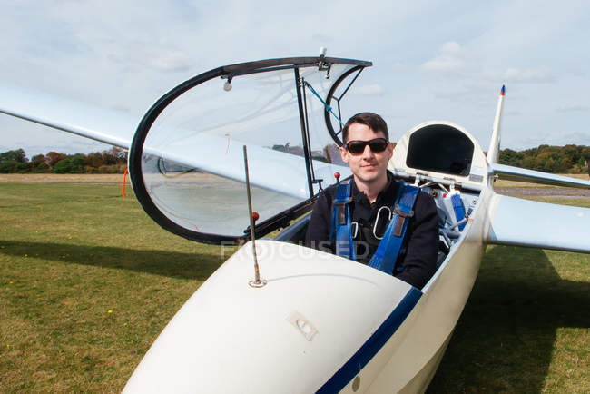 Mann sitzt im Segelflugzeug und blickt in Kamera — Stockfoto
