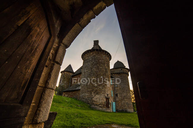 Живописный вид на замок из-за открытой двери, Обен, Франция — стоковое фото