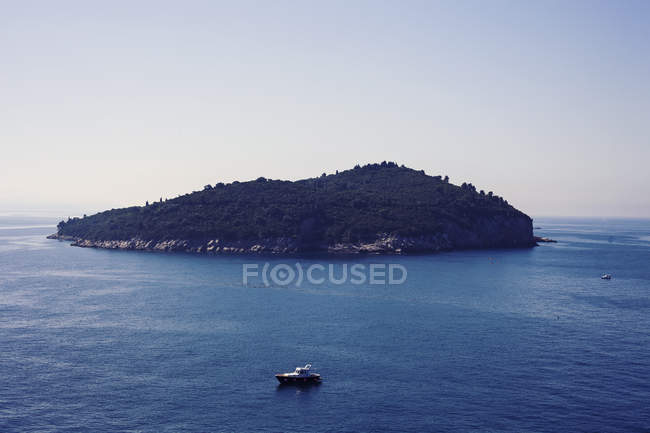 Живописный вид на остров с лодками на переднем плане, Хорватия — стоковое фото