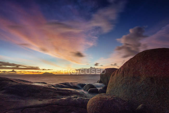 Vista panorámica de la puesta de sol sobre la playa de Tanjung Bajau, Singkawang, Indonesia - foto de stock