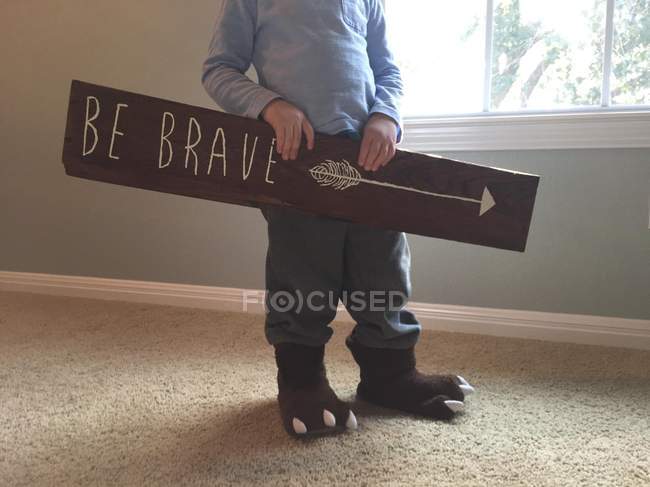 Divertente piccolo ragazzo holding essere coraggioso segno in mani — Foto stock