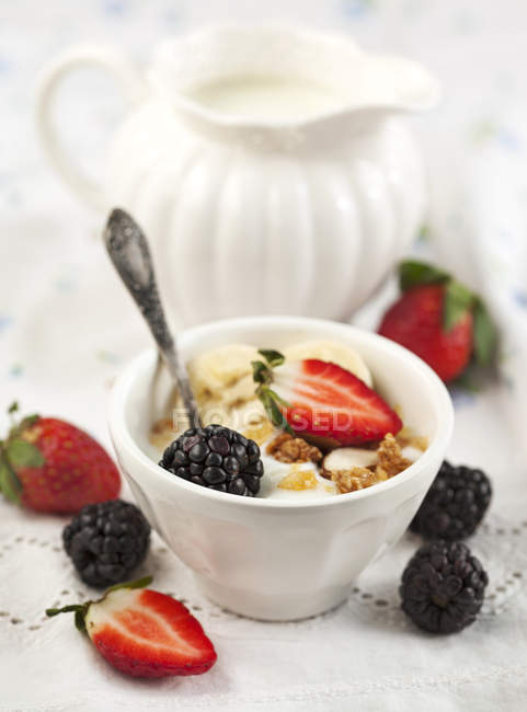 Cuenco de yogur y muesli con bayas frescas en blanco - foto de stock