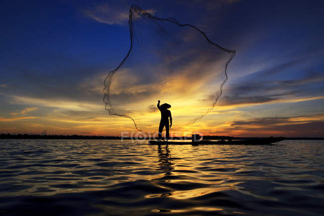 Silhouette eines Mannes, der Fischkörbe in den Mekong wirft, Thailand — Stockfoto