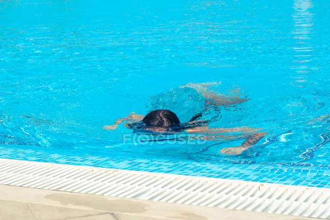 Menina nadando debaixo d 'água na piscina — Fotografia de Stock