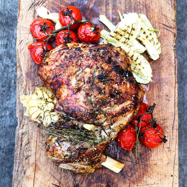 Top view of tempting roasted lamb and vegetables over wooden board — Stock Photo