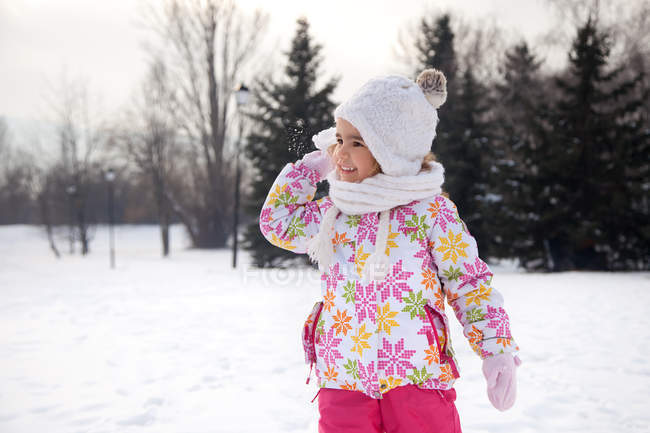 Girl throwing a snowball outdoors in winter — Stock Photo