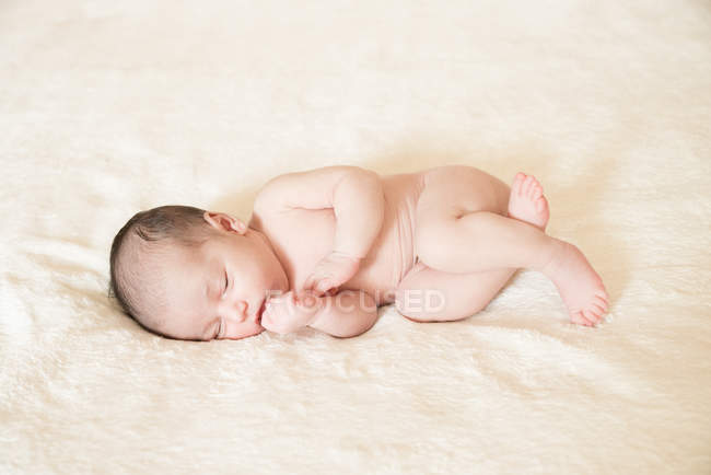 Голый новорожденный мальчик спит на одеяле — стоковое фото