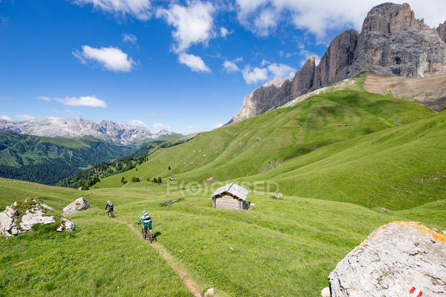 Man and woman mountain biking along trail, Dolomites, Italy — Stock Photo