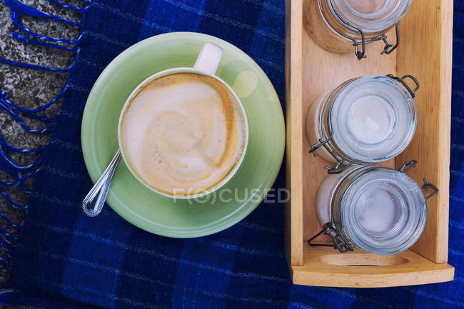 Cappuccino coffee with jars of sugar, top view — Stock Photo