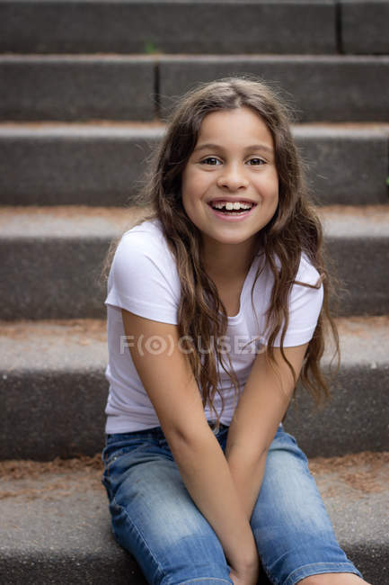 Portrait de fille mignonne assise sur les escaliers à l'extérieur — Photo de stock