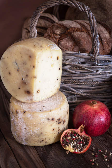 Pão, queijo e romã na superfície de madeira — Fotografia de Stock