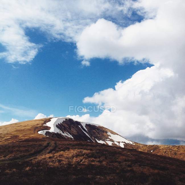 Vue panoramique sur la montagne avec nuages au ciel bleu — Photo de stock