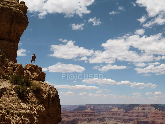 США, Аризона, Гранд-Каньон, Турист, стоящий на краю утеса и смотрящий на вид — стоковое фото