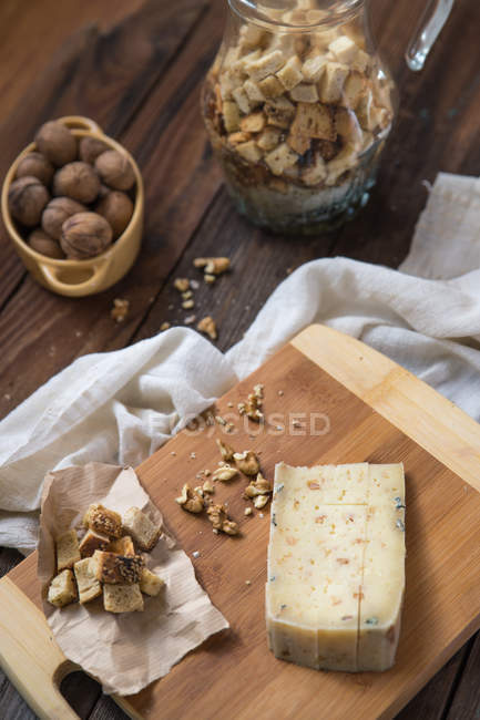 Сир з грінками та волоськими горіхами на дерев'яному столі — стокове фото