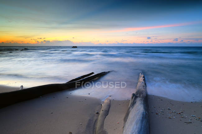 Vista panorâmica da madeira à deriva na praia ao pôr do sol, Sabah, Bornéu, Malásia — Fotografia de Stock