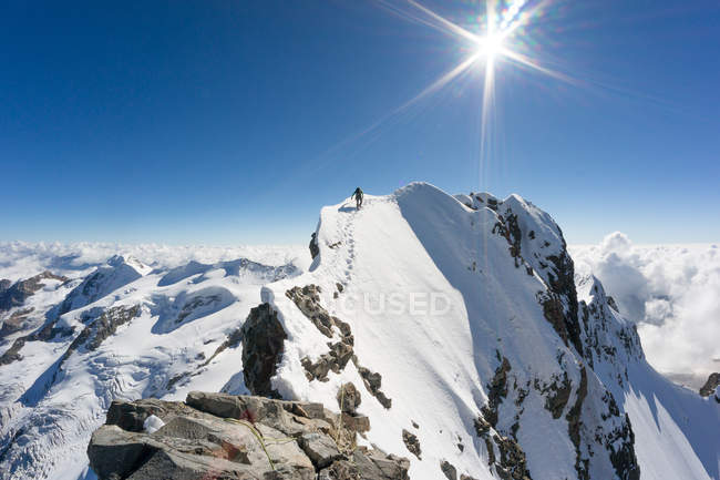 Hombre llegando a la cima de la montaña Piz Bernina, Alpes suizos, Graubunden, Suiza - foto de stock