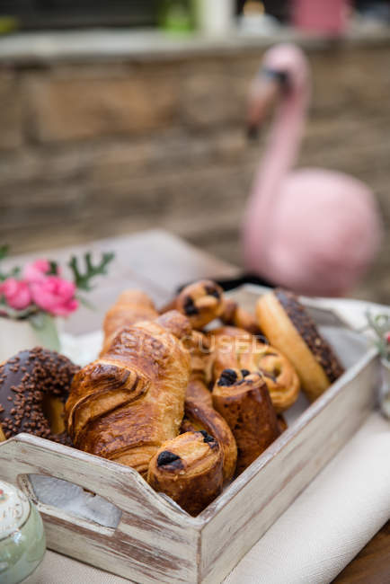 Close-up of croissants and donuts on tray against blurred background — Stock Photo