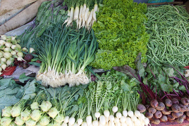 Close-up of fresh picked vegetables and greens at farmer market — Stock Photo