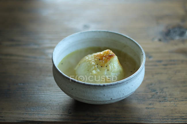 Bowl of tasty soup over wooden table — Stock Photo