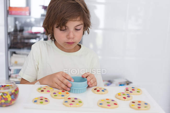 Focado Menino fazendo biscoitos na cozinha — Fotografia de Stock