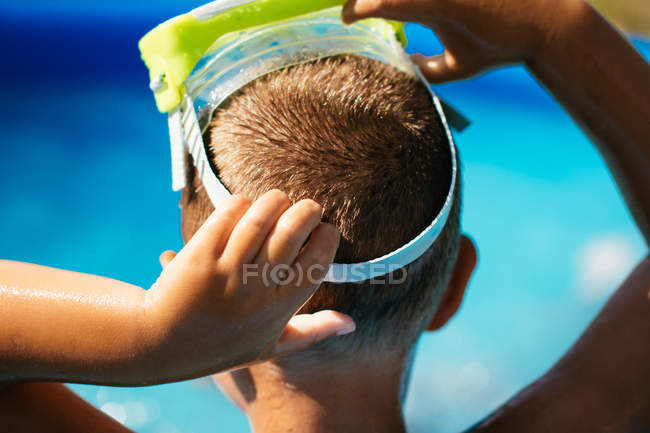 Close-up of Boy putting on diving mask — Stock Photo