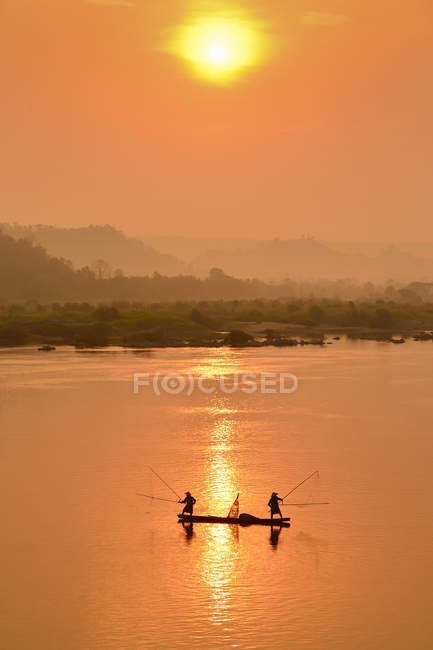 Silhouette de deux pêcheurs en bateau sur le Mékong, Thaïlande — Photo de stock
