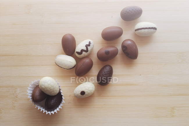 Chocolate branco, chocolate escuro e ovos de Páscoa de chocolate com leite sobre fundo de madeira — Fotografia de Stock