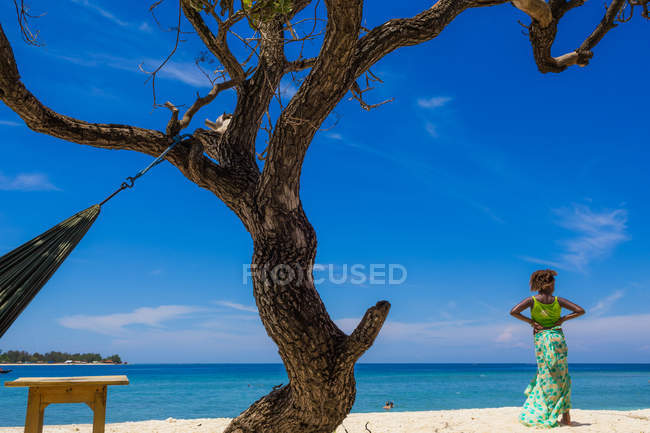 Girl standing on beach and looking at ocean, Indonesia — Stock Photo