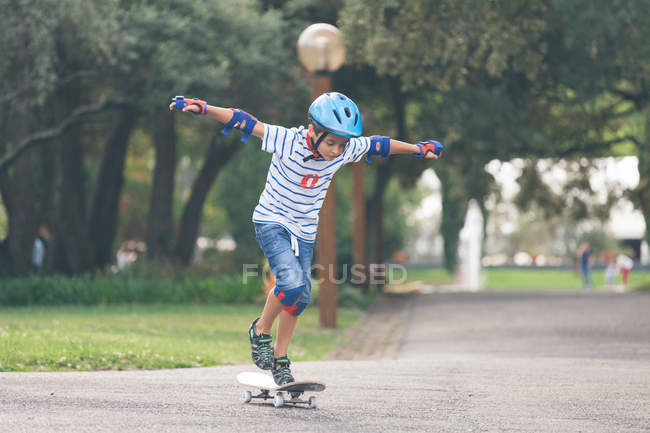 Ragazzo che indossa casco skateboard nel parco — Foto stock