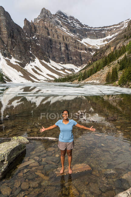 Afro-américaine debout avec les bras tendus, lac Agnes, parc national Banff, Alberta, Canada — Photo de stock