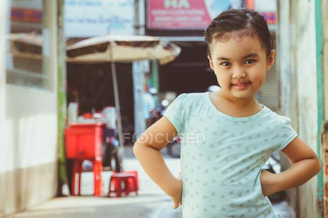 Девушка, стоящая с руками на бедрах на улице — стоковое фото
