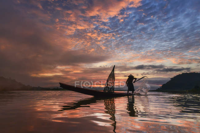 Silhouette di un uomo che lancia reti da pesca, fiume Mekong, Sangkhom, Thailandia — Foto stock