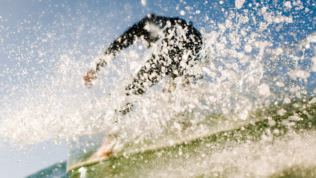Surfeur confiant sur la vague avec éclaboussures dans l'océan — Photo de stock