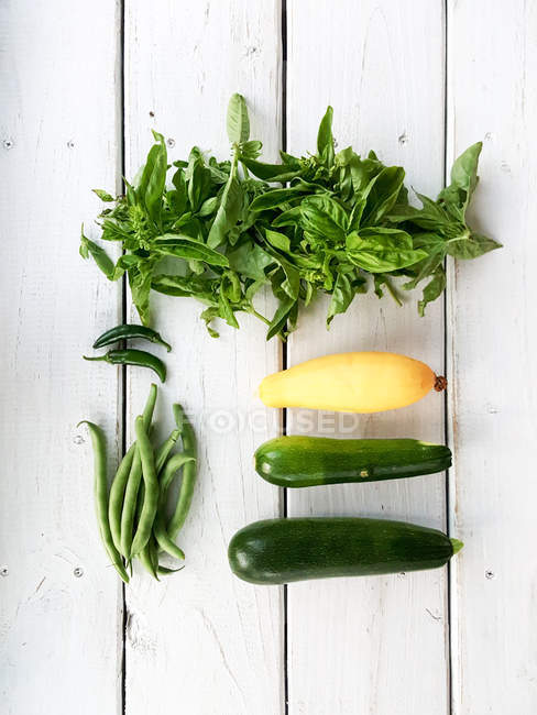 Overhead view of fresh zucchini, squash, peppers, beans and basil — Stock Photo
