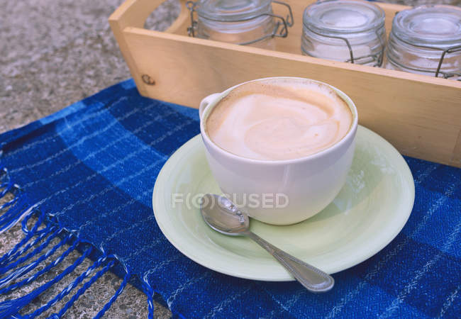 Tazza di caffè e zucchero sopra un asciugamano blu — Foto stock