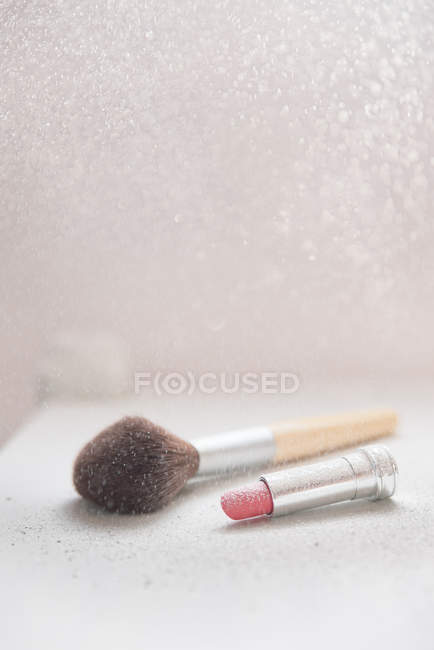 Vista close-up de batom e pincel de maquiagem — Fotografia de Stock