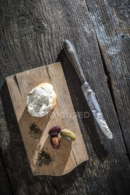 Bruschetta with soft cream cheese and olives on chopping board — Stock Photo