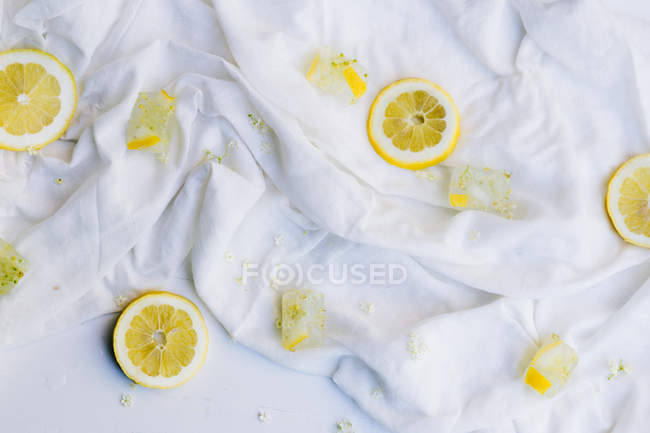 Slices of lemon and ice cubes with lemon and elderflower — Stock Photo